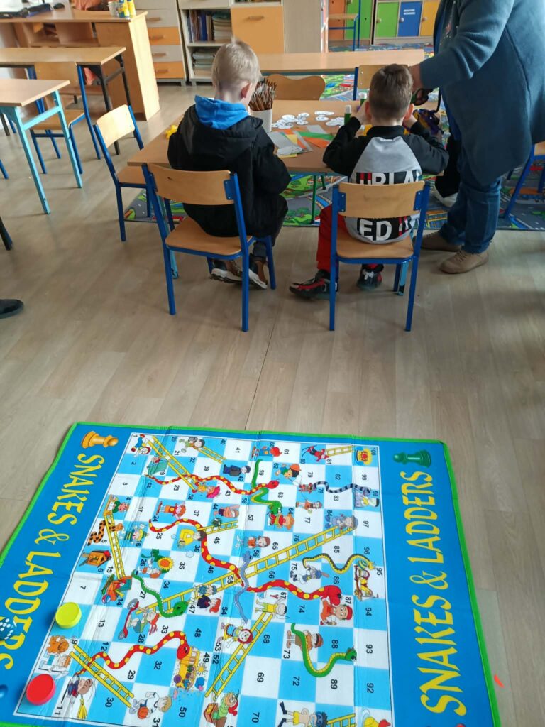 dzieci siedzą w ławkach 