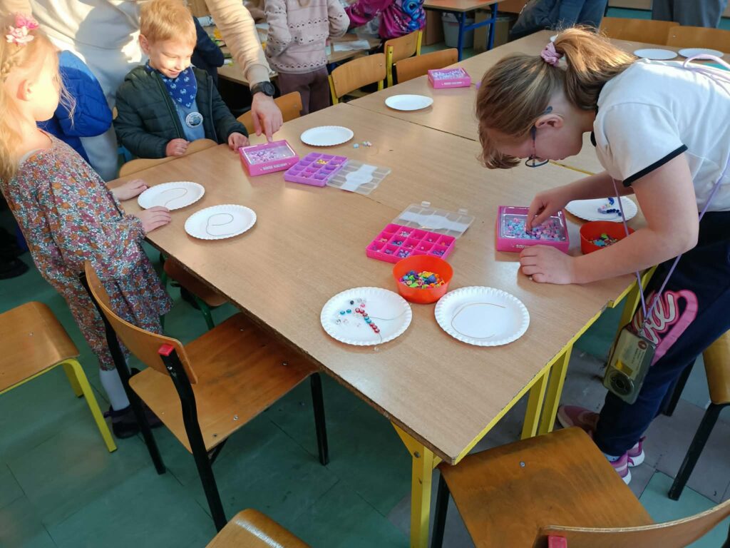 dzieci wykonują prace w ławkach z talerzami