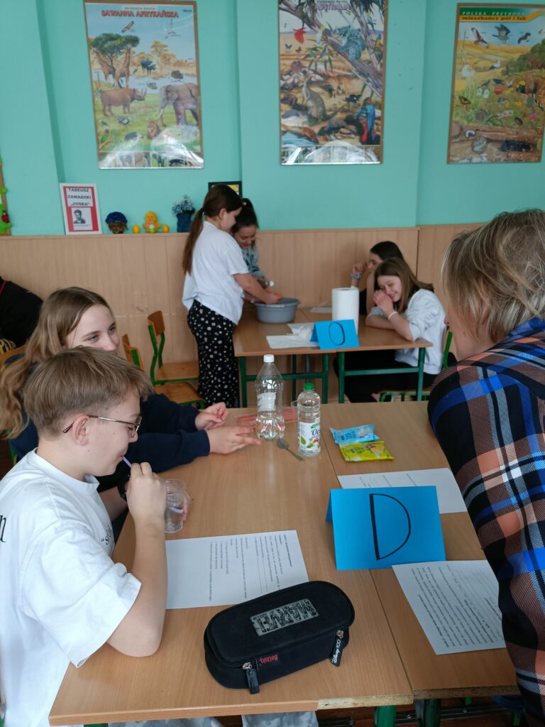 dzieci rozwiązują zadania siedząc w ławkach