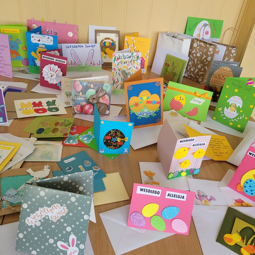 Kolorowe świąteczne kartki "Podaruj świąteczne życzenia" - Wielkanoc, ustawione na ławkach w sali lekcyjnej, zbliżenie.