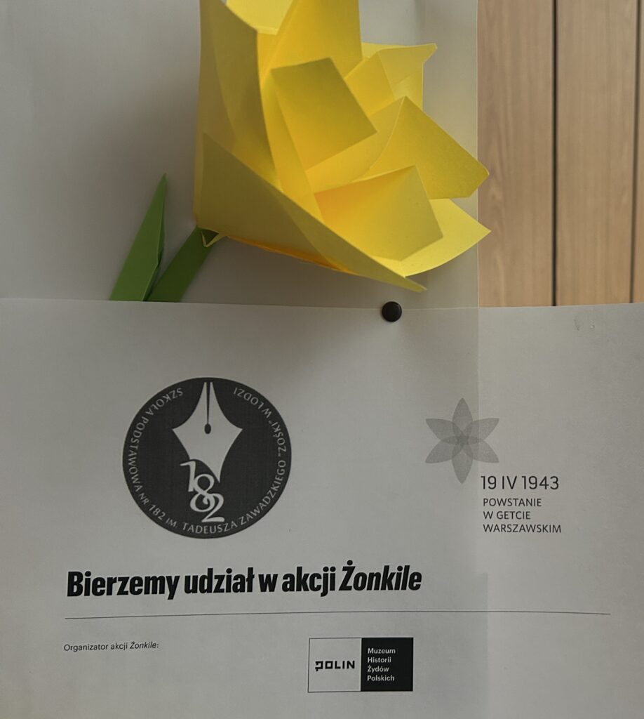 kartka z napisem bierzemy udział w akcji żonkile, logo naszej szkoły i data 19 IV 1943 powstanie w getcie warszawskim, dołączony żółty kwiat z papieru