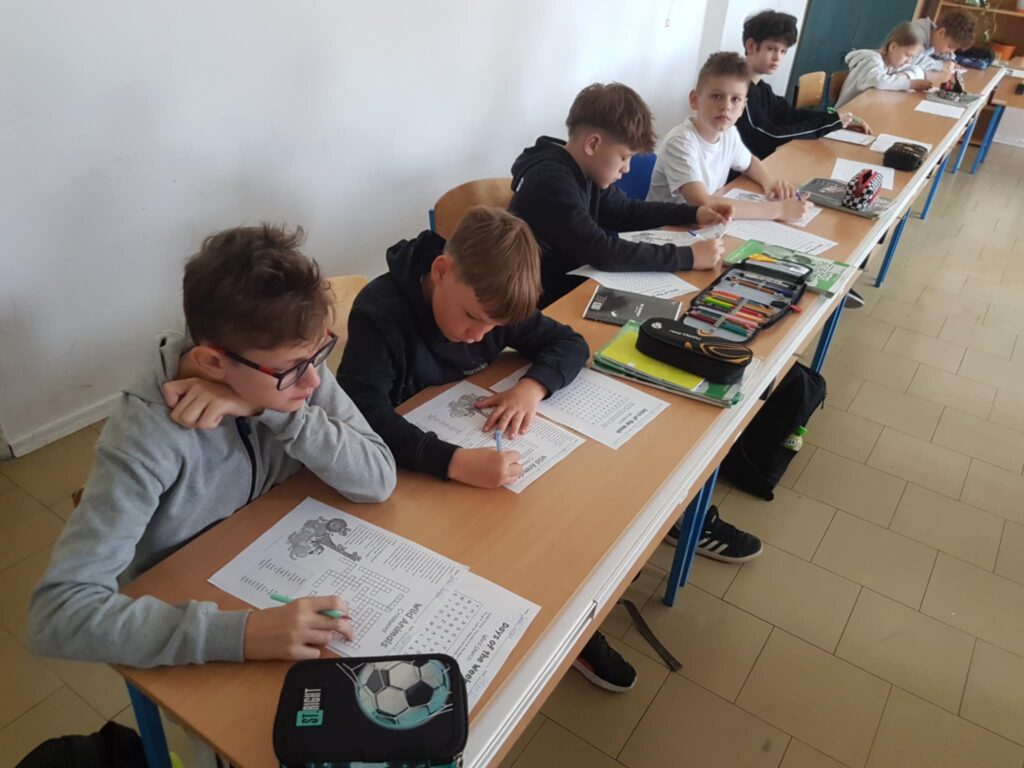 zdjęcie uczniów, siedzących w ławkach obok siebie