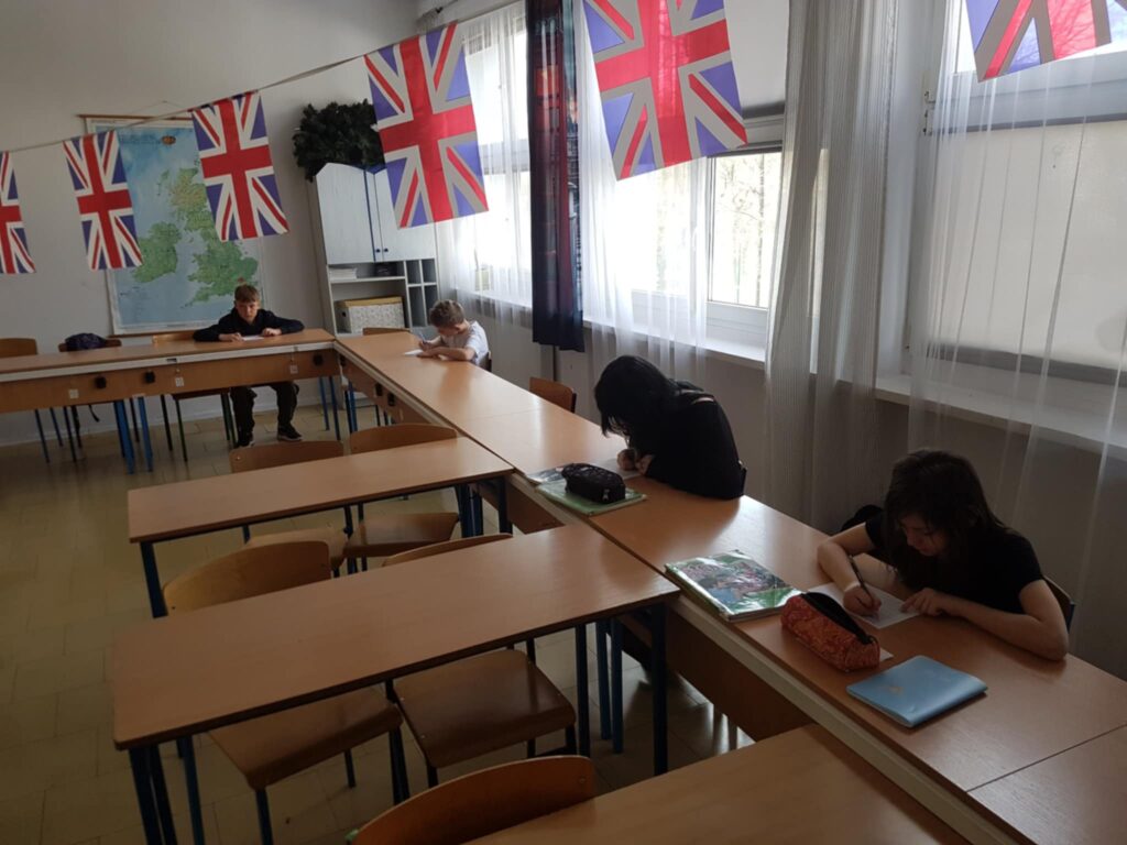 zdjęcie uczniów siedzących w ławkach, rozwiązują zadania