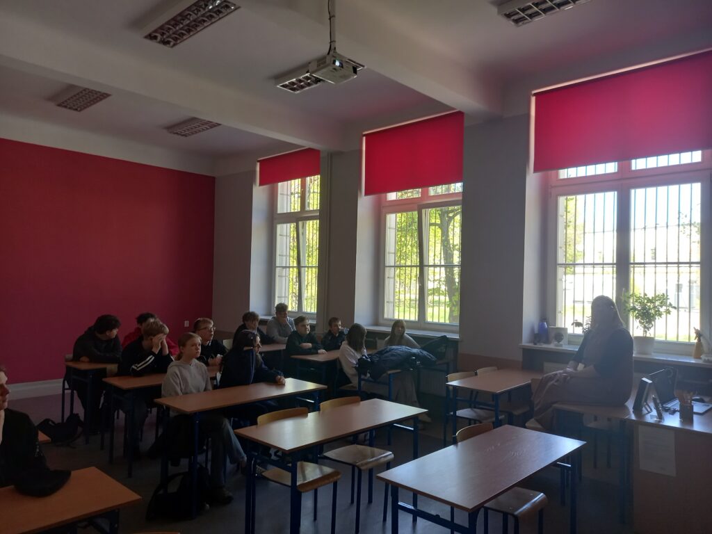 dzieci siedzą w ławkach 