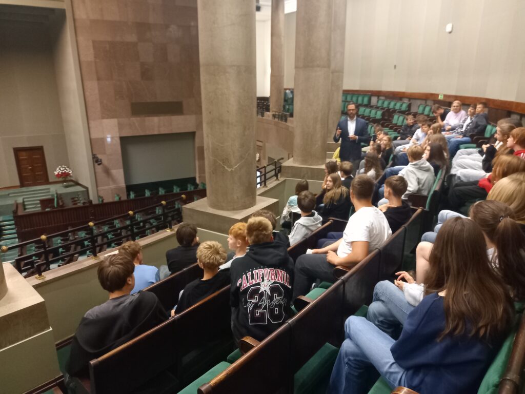 dzieci siedzą w jednaj z sali plenarnych