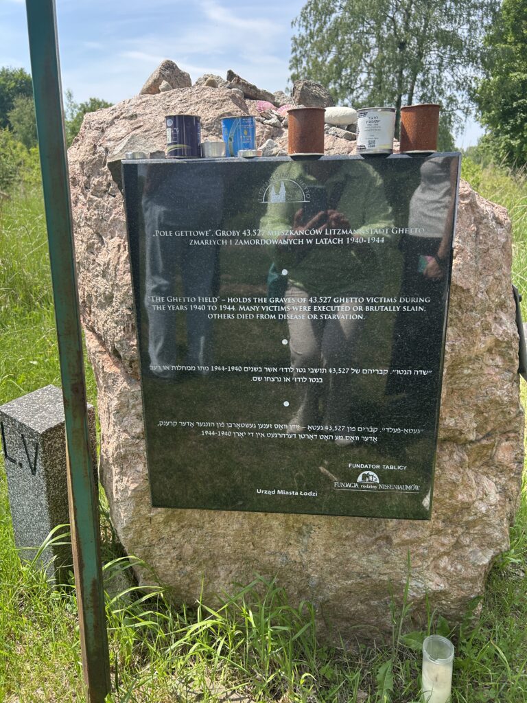 na duzym kamieniu czarna tablica z napisem Pole Gettowe w kilku językach