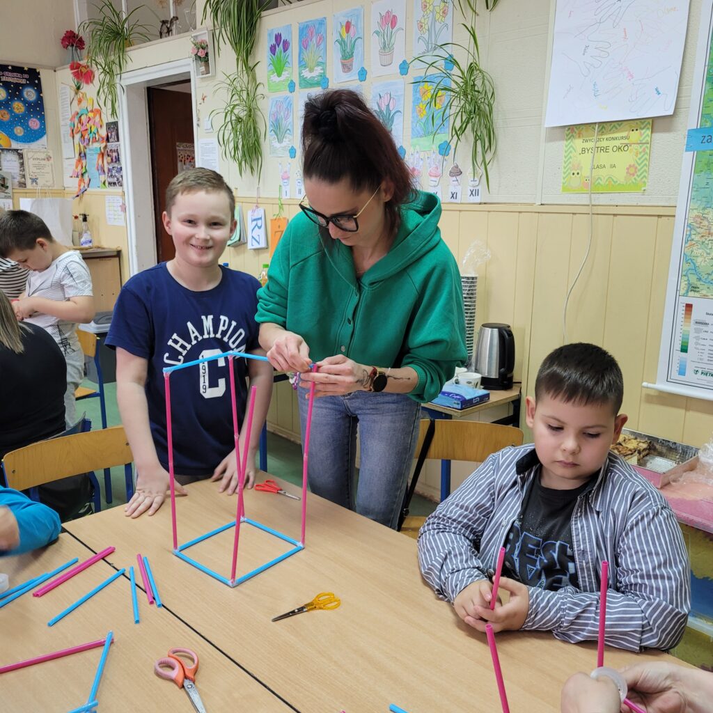 dzieci i rodzice budują razem ze słomek specjalnych kolorowych do łączenia