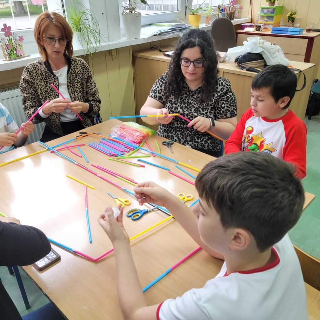 dzieci i rodzice budują razem ze słomek specjalnych kolorowych do łączenia
