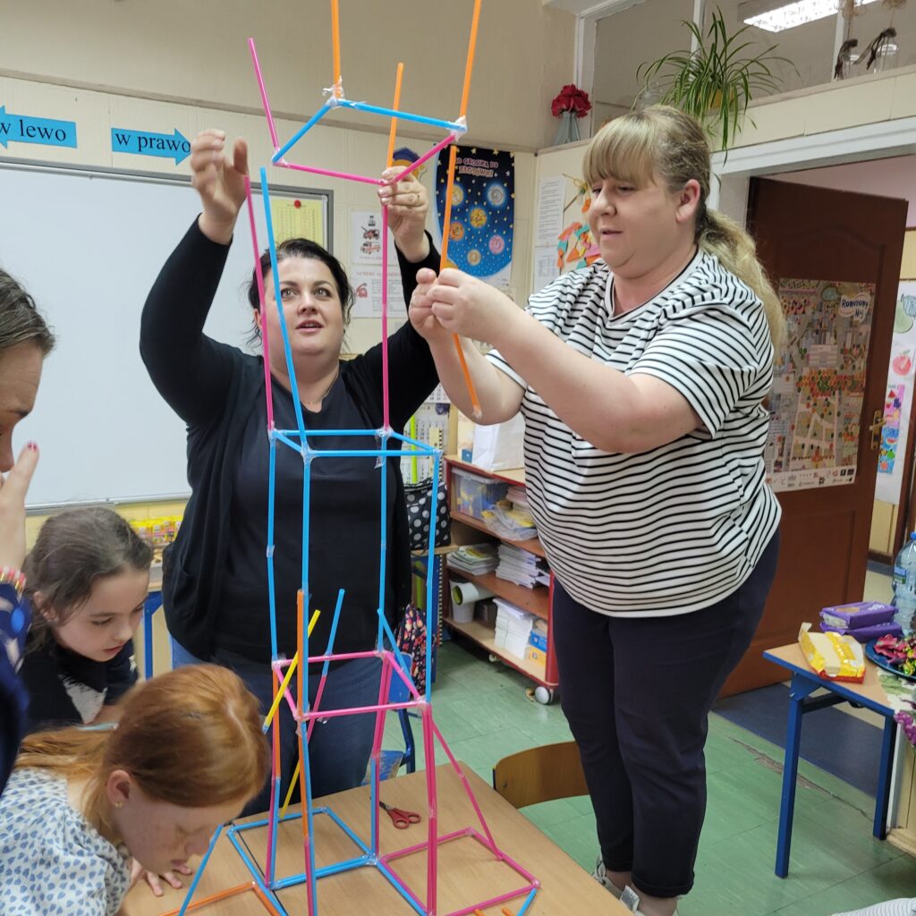 dzieci i rodzice budują razem ze słomek specjalnych kolorowych do łączenia