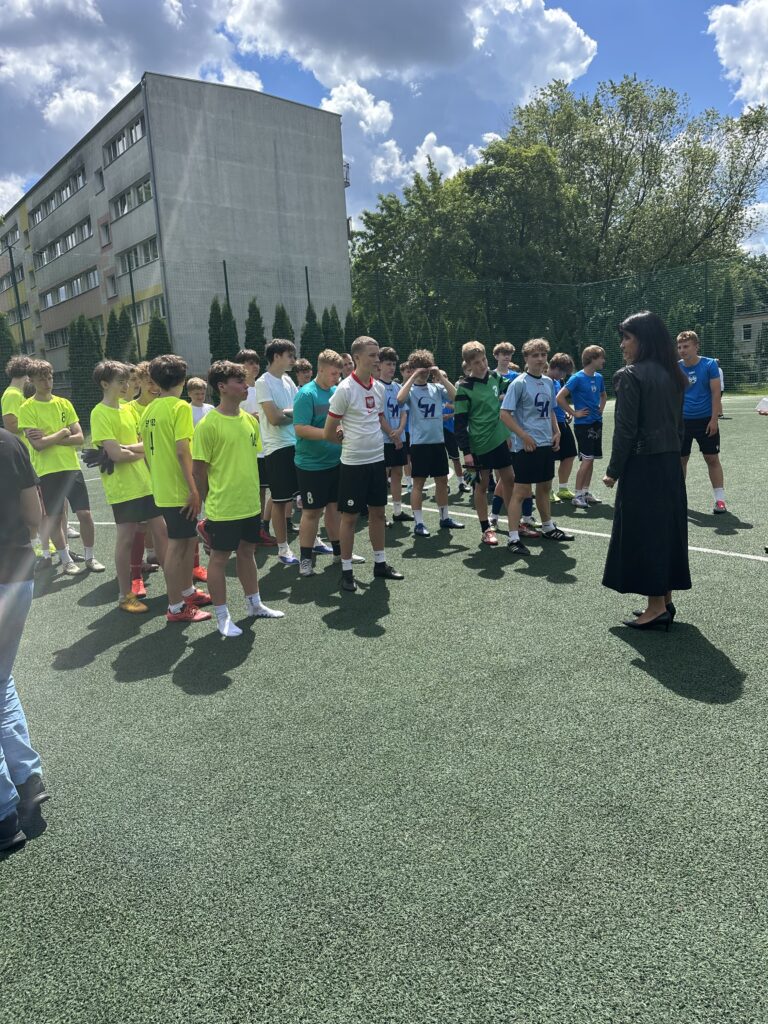 uczniowie stoją w kolejkach, jedni za drugimi, podzieleni drużynowo