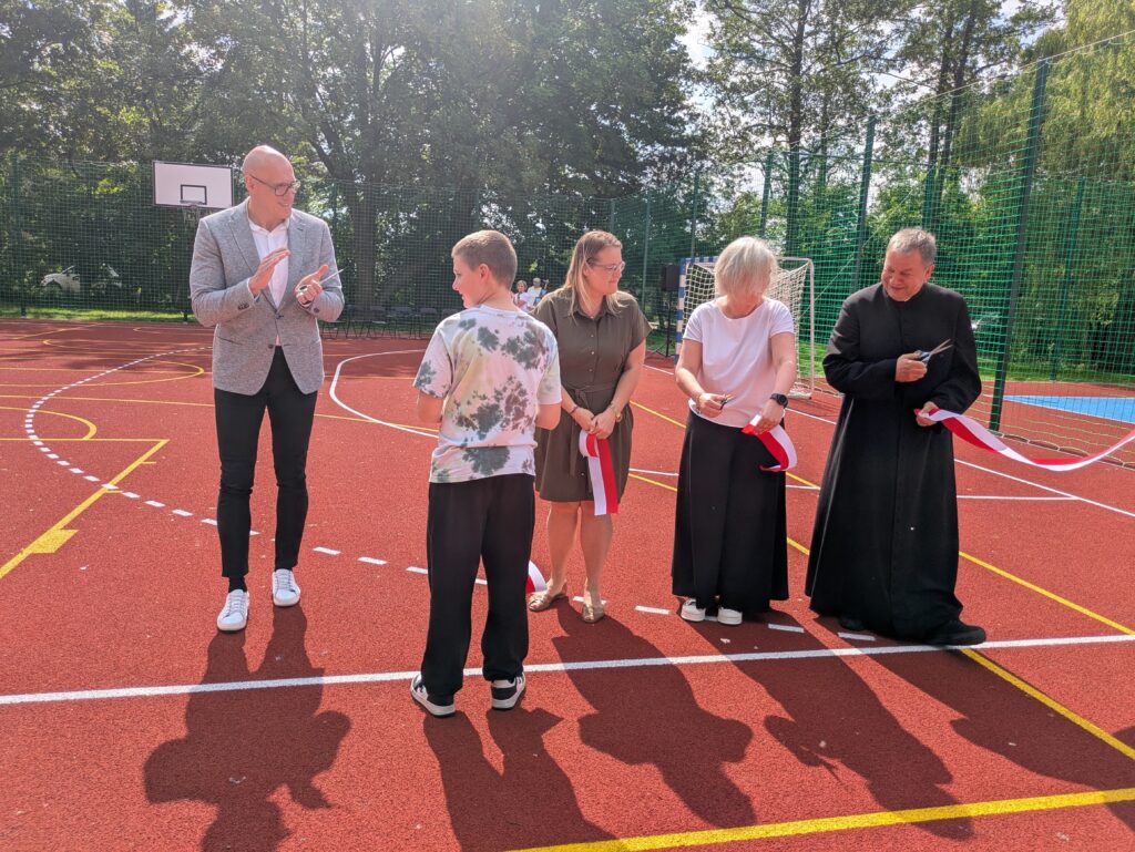 cztery osoby przecinają wstęgę, widać jednego z uczniów który ją trzyma
