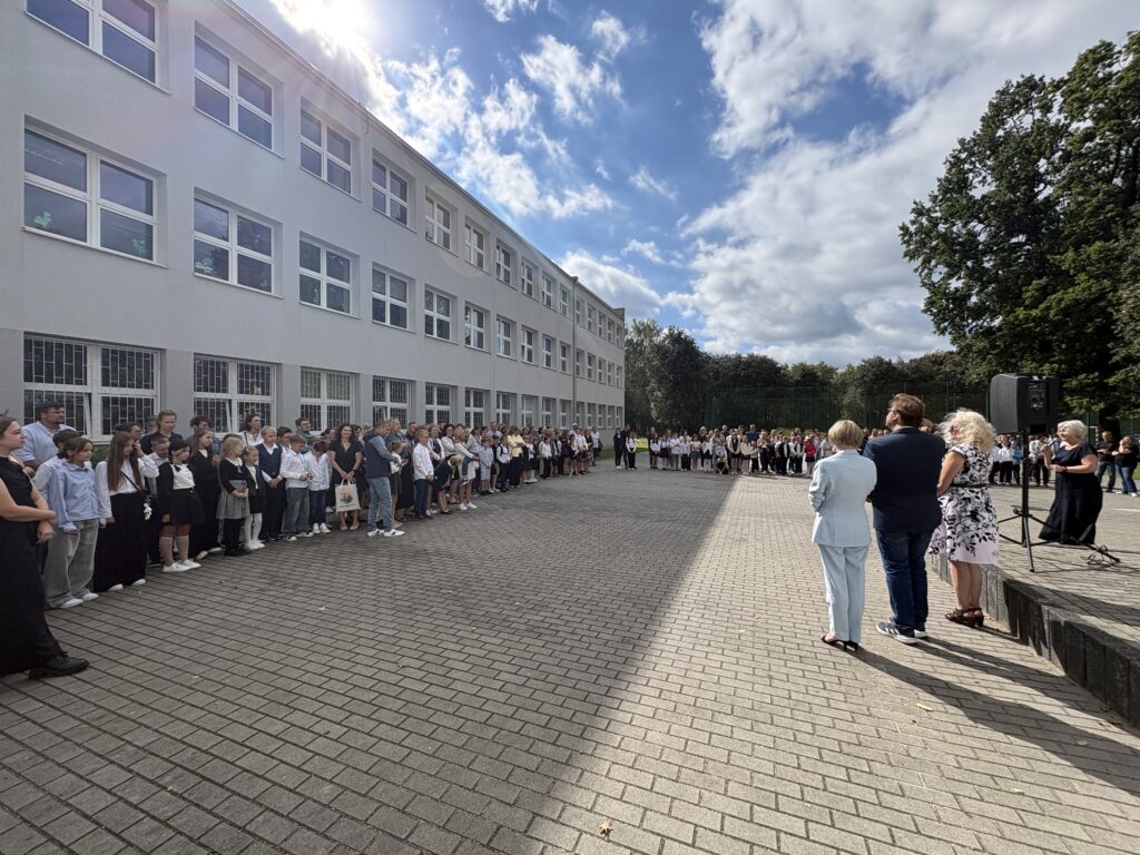 zdjęcie z daleka, zgromadzeni uczniowie i rodzice wokół Dyrekcji, inny kadr