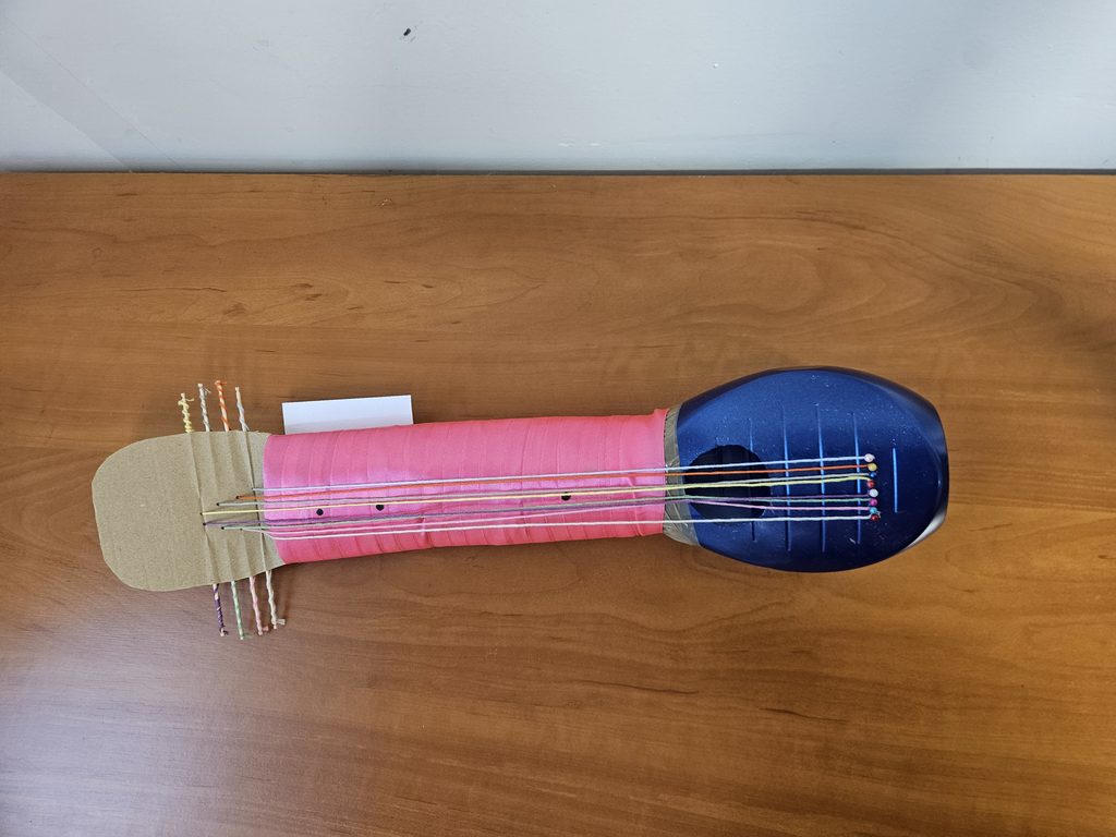zdjęcie przedstawia instrument wykonany z papieru i nitek