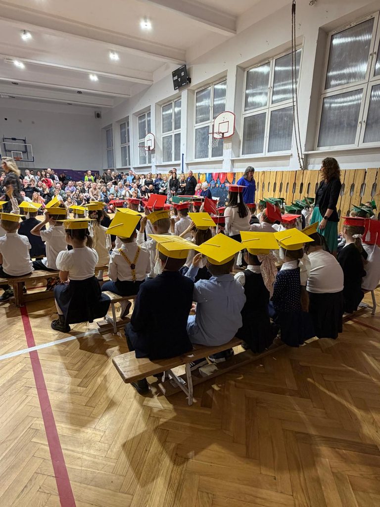 dzieci siedzą na ławkach zdjęcie z tyłu