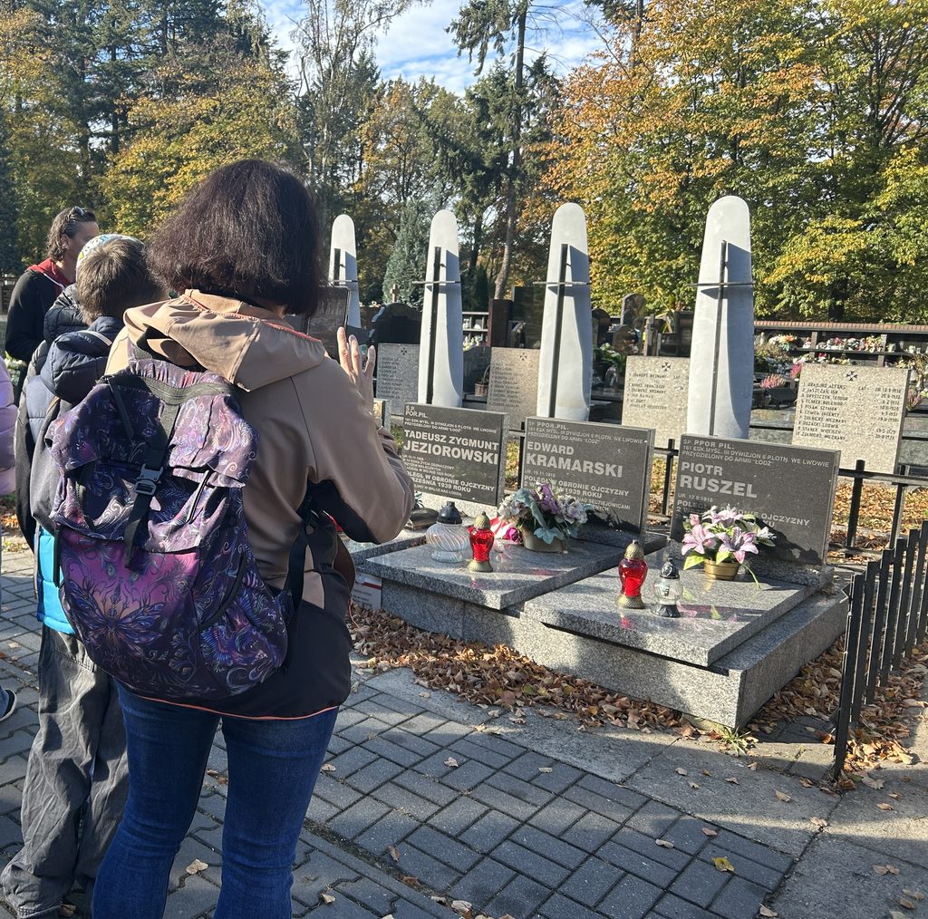 pani i dzieci patrzą na groby żołnierzy, którzy zginęli w czasie 2 wojny św.