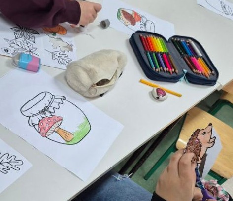 piórnik, kartki z rysunkiem słoików z namalowanymi ozdobami, ręce dzieci malujące